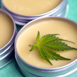 Cannabis salve with hemp and CBD oil on green background