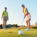 Competitive woman looking at the golf ball with disappointment