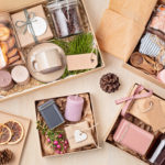 Preparing care package, seasonal gift box with coffee, cookies, candles, spices and cups