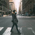 woman wearing surgical mask going through crosswalk in new york, midtown Manhattan