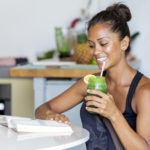 Latin woman staying healthy at home having a green juice