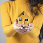 woman holding house model