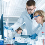 In Modern Laboratory Senior Female Scientist Has Discussion with