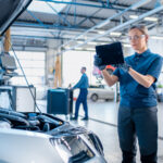 Female Mechanic Uses a Tablet Computer with an Augmented Reality