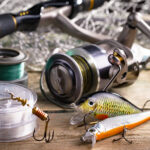 fishing tackle on a wooden table. toned image