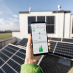 Woman monitors energy production from the solar power plant with a digital tablet