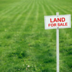 land for sale sign against trimmed lawn background