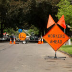 Orange and Black “Workers Ahead” Sign in Residential Neighborhoo
