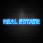 Real Estate neon Sign on brickwall